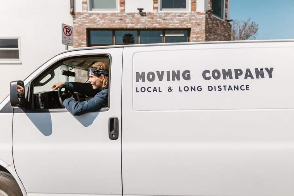 pexels-photo-7464395 - EZ Movers | New Orleans Moving Company White moving van with 'MOVING COMPANY' lettering on the side; the driver is visible in the cab window.